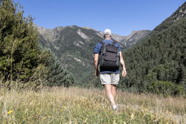 Orta yaşlı Kafkasyalı turist İspanyol Pireneleri Dağı 'nda yürüyor
