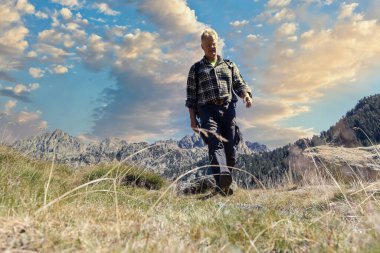 Male middle aged caucasian tourist walking by Spanish Pyrenees mountain during sunny day clipart