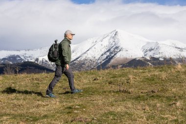 Orta yaşlı Kafkasyalı turist kışın İspanyol Pireneleri dağında yürüyor