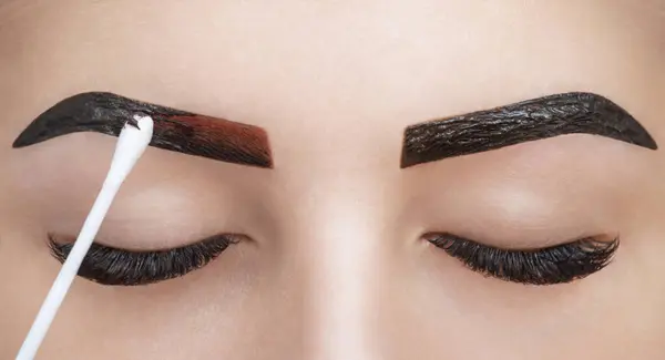 化妆师在美容院的眉毛上涂上指甲油 面部的专业护理 — 图库照片