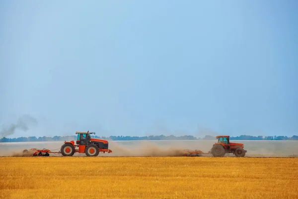 夏の日 2台のトラクターが トウモロコシ畑で 土壌を耕します 植える前の農地処理 — ストック写真