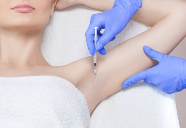 Doktor koltukaltı bölgesinde hiperhidrosite karşı botulinyum iğnesi yapıyor..