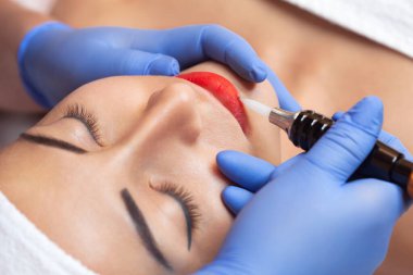 Kalıcı makyaj Güzellik Salonu içinde güzel kadın kırmızı dudaklar için. Tatlı Şevval Özçelik Güzellik dudak dövme yapıyor.