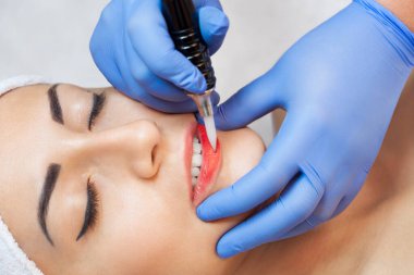 Kalıcı makyaj Güzellik Salonu içinde güzel kadın kırmızı dudaklar için. Tatlı Şevval Özçelik Güzellik dudak dövme yapıyor.