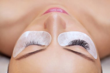 Kirpik temizleme prosedürünü kapat. Güzellik salonunda uzun kirpikleri olan güzel bir kadın. Kirpik uzantısı.