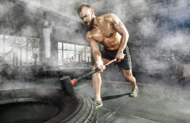 Spor kas adam spor salonunda çekiç Sledge ile tekerlek lastiği vurmak. Spor eğitimi