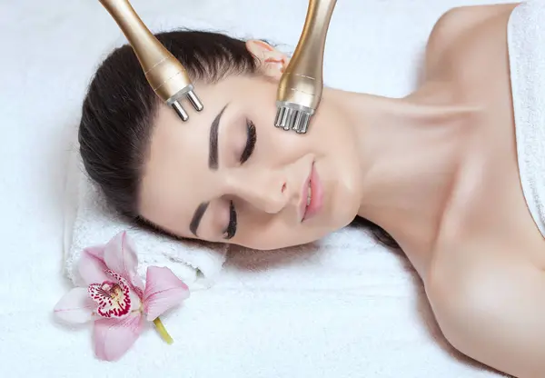 Beautician does the procedure rf-lifting on face and neck. Rf lifting procedure in a beauty parlour.
