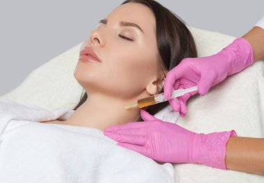 Kozmetik uzmanı güzellik salonundaki güzel bir kadının boynunda terapi yapıyor. Kozmetoloji konsepti..