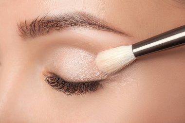 Güzel bir kadının portresi. Uzun kirpikleri, güzel makyajı, kalın kaşları ve güzellik salonunda temiz bir teni var. Kirpik uzantıları. Makyaj ve kozmetoloji kavramı.