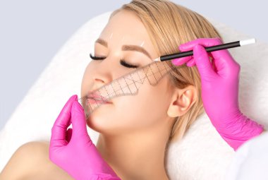 Gözlerinde kalıcı makyaj dövmesi olan bir kadın. Güzellik salonundaki kaşların kalıcı makyajı. Yakından bir güzellik uzmanı kaş dövmesi yapıyor. Profesyonel makyaj ve kozmetoloji cilt bakımı.