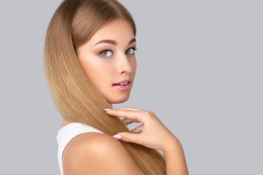 Temiz ciltli, güzel makyajlı, uzun, sağlıklı, parlak sarı saçlı güzel bir genç. Saç eklentisi yapıyordu. Makyaj konsepti, estetik kozmetoloji ve saç bakımı.
