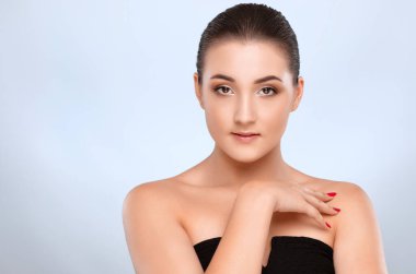 Çekici esmer bir kızın portresi sağlıklı, temiz ciltli ve taze makyajlı. Estetik kozmetoloji ve makyaj konsepti.