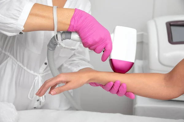 Bir kadının vücudunda Elos epilasyon tüy çıkarma prosedürü. Güzellik uzmanı bir güzellik salonunda eline lazer gençleştirme yapıyor. Yüz bakımı. Donanım ipl kozmetolojisi