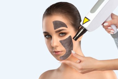 Güzellik uzmanı kaşlarından güzel bir kadına lazer dövme yaptırıyor. Güzellik salonunda donanım kozmetoloji tedavisi.