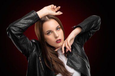 Güzel makyajlı esmer kız, temiz tenli, uzun saçlı, siyah deri ceketli..