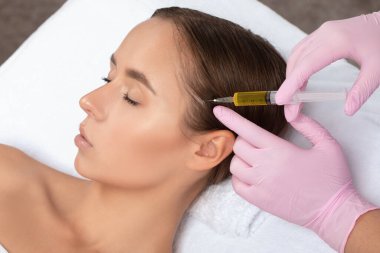 Kozmetik uzmanı kuaförde saç dökülmesine ve kepek önleyici bir kadına karşı terapi uygular. Kozmetoloji kavramı.