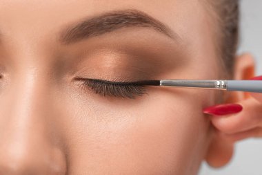 Gözler ve kaşlar kapanır. Güzel makyajlı ve sağlıklı ciltli güzel bir genç kızın portresi. Makyöz göz makyajı yapar. Makyaj konsepti..