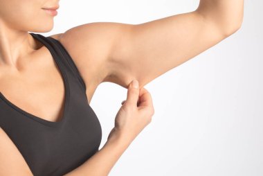 İnce bir kadın kolundaki sarkık deriyi gösterir. Düzgün beslenme ve sağlıklı yaşam tarzı kavramı.