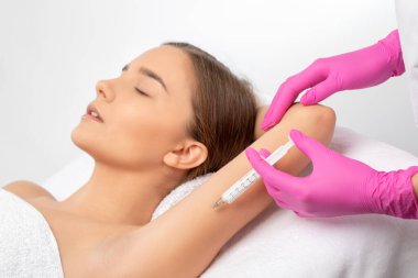 Estetik kozmetik uzmanı bir kadının kolunda ve vücudunda yağ yakmak için lipolitik enjeksiyon yapar. Güzellik salonunda kadın estetiği. Kozmetoloji konsepti..