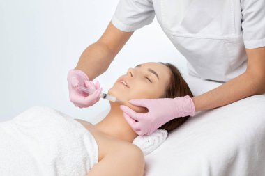 Kozmetik uzmanı, bir kadının çenesinde, yanaklarında ve boynunda çift çeneye karşı yağ yakmak için lipolitik enjeksiyon yapar. Güzellik salonunda kadın estetiği. Kozmetoloji konsepti..