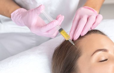 Kozmetik uzmanı kuaförde saç dökülmesine ve kepek önleyici bir kadına karşı terapi uygular. Estetik kozmetoloji konsepti, saç tedavisi.