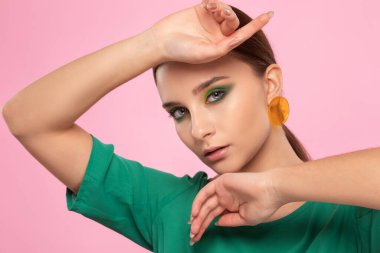 Güzel yeşil makyajlı, temiz tenli, yuvarlak küpeli esmer kız. Makyaj konsepti. Güzel yeşil makyajlı, temiz tenli, yuvarlak küpeli esmer kız. Makyaj konsepti.