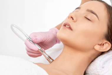 Kozmetik uzmanı sivilcelere ve siyah noktalara karşı mikro cilt bakımı yapıyor. Güzellik salonunda kadın kozmetolojisi.