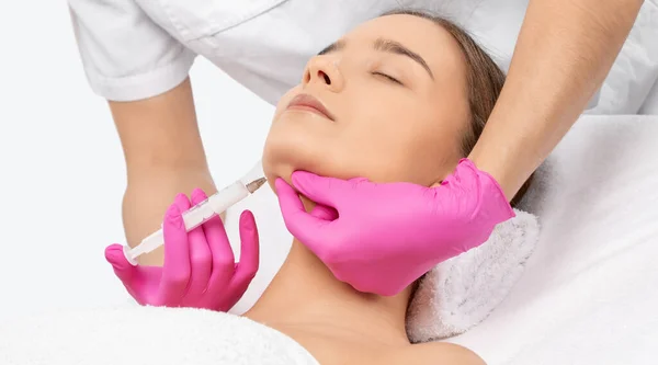 stock image Cosmetologist makes lipolytic injections to burn fat on the chin, cheeks and neck of a woman against double chin. Female aesthetic cosmetology in a beauty salon.Cosmetology concept.