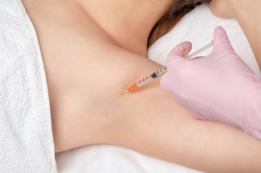 Doktor koltukaltı bölgesinde hiperhidrosite karşı botulinyum toksini enjekte ediyor. Kadın kozmetolojisi kavramı.