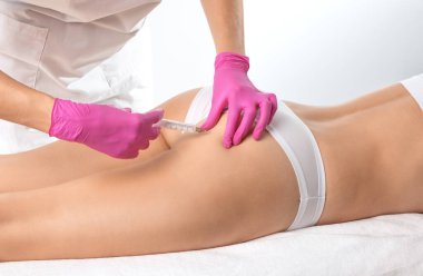 Estetik kozmetik doktoru kadın karnında ve vücudunda yağ yakmak için lipolitik enjeksiyon yapar. Güzellik salonunda kadın estetiği..