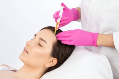 Kozmetik uzmanı kuaförde saç dökülmesine ve kepek önleyici bir kadına karşı terapi uygular. Estetik kozmetoloji konsepti, saç tedavisi.