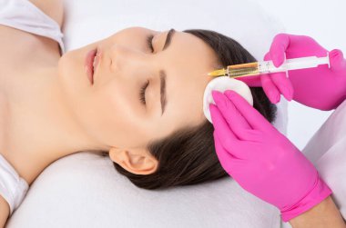 Kozmetik uzmanı güzellik salonunda güzel bir kadının terapisini yapıyor. Kozmetoloji kavramı.