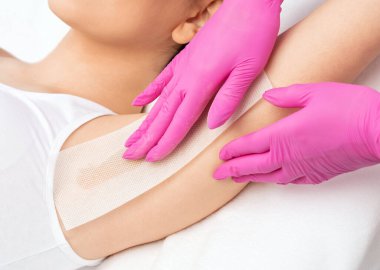 Güzellik uzmanı, güzellik salonundaki koltukaltların altında şeker macunu tüyü yapar. Kadın estetik kozmetolojisi.