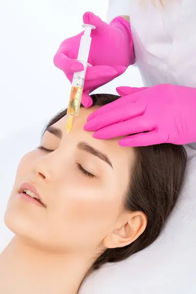 stock image Cosmetologist does prp therapy on the face of a beautiful woman in a beauty salon. Cosmetology concept.