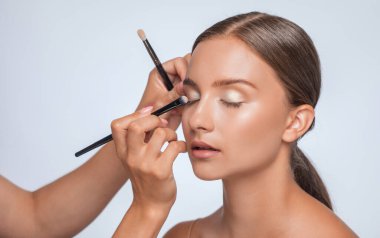 Uzun kirpikleri, güzel makyajı ve kalın kaşları olan güzel bir kadın. Profesyonel makyaj ve kozmetoloji cilt bakımı.