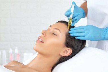 Kozmetik uzmanı güzellik salonunda güzel bir kadının terapisini yapıyor. Kozmetoloji kavramı.