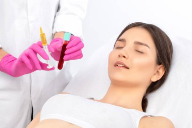 Kozmetik uzmanı güzellik salonunda güzel bir kadının yüzü üzerinde terapi uygular. Kozmetoloji kavramı.