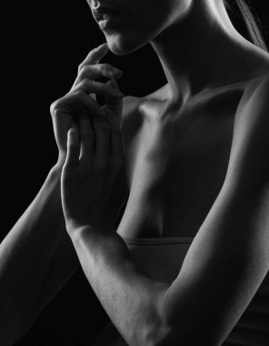 Kadın omuzlarının ve ellerinin siyah-beyaz silueti. Kadın silueti. Kız ellerini kavuşturmuş..