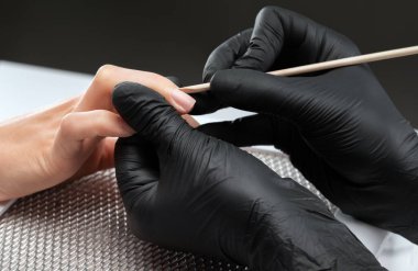 Manikürcü, kuaförde tırnak etlerini söker. Profesyonel el bakımı..