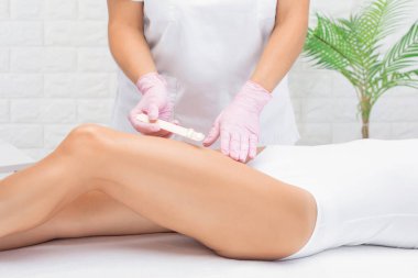 Bir kadının vücudunda epilasyon tüy çıkarma prosedürü. Güzellik uzmanı bir güzellik salonunda lazer gençleştirme yapıyor. İstenmeyen vücut kılları alınıyor. Donanım ipl kozmetolojisi