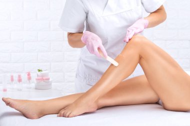 Bir kadının vücudunda epilasyon tüy çıkarma prosedürü. Güzellik uzmanı bir güzellik salonunda lazer gençleştirme yapıyor. İstenmeyen vücut kılları alınıyor. Donanım ipl kozmetolojisi