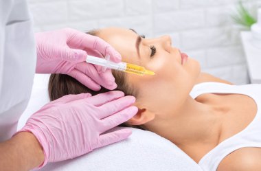 Kozmetik uzmanı güzellik salonunda güzel bir kadının terapisini yapıyor. Kozmetoloji kavramı.