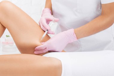 Estetik kozmetik uzmanı bir kadının kalçasında, kalçasında ve vücudunda yağ yakmak için lipolitik enjeksiyonlar yapar. Güzellik salonunda kadın estetiği. Kozmetoloji konsepti..