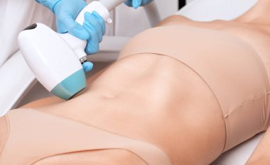 Bir kadının vücudunda epilasyon tüy çıkarma prosedürü. Güzellik uzmanı bir güzellik salonunda bacağının alt kısmında lazer gençleştirme yapıyor. İstenmeyen vücut kılları alınıyor. Donanım ipl kozmetolojisi