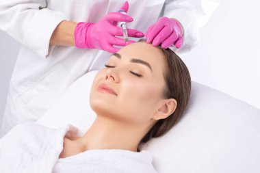 Kozmetik uzmanı güzellik salonunda güzel bir kadının terapisini yapıyor. Kozmetoloji kavramı.