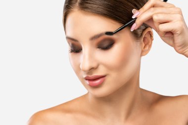 Makyöz güzellik salonunda kaşlarını tarar. Profesyonel makyaj ve estetik cilt bakımı.