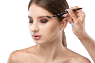 Makyöz güzellik salonunda kaşlarını tarar. Profesyonel makyaj ve estetik cilt bakımı.