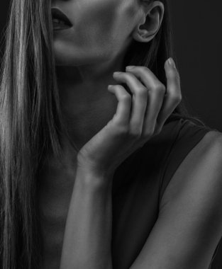 Güzel genç bir kadın elini yüzüne yaklaştırdı. Fotoğraf siyah beyaz..