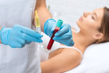 Kozmetik uzmanı güzellik salonunda güzel bir kadının yüzü üzerinde terapi uygular. Kozmetoloji kavramı.