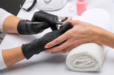 Manikürcü, kuaförde tırnak etlerini söker. Profesyonel el bakımı..